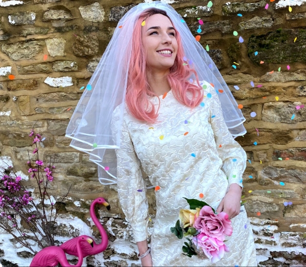 Bride in preloved wedding dresses showered in confetti