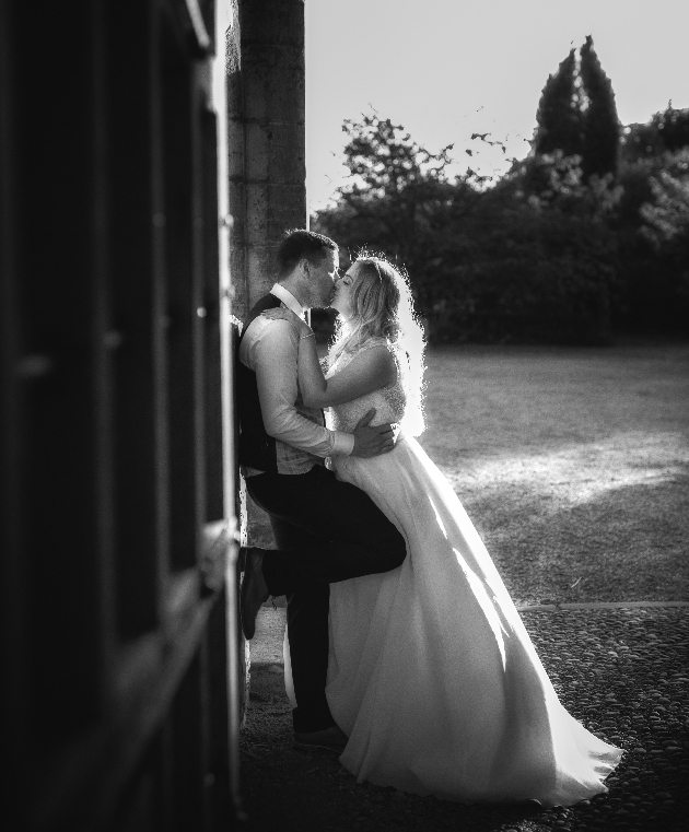 Black and white image of couple kissing on their wedding day taken by Nick Shoot Photography