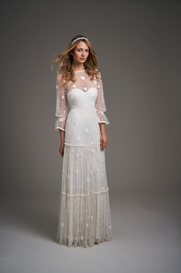 Model in a studio wearing a tiered pretty detailed wedding gown