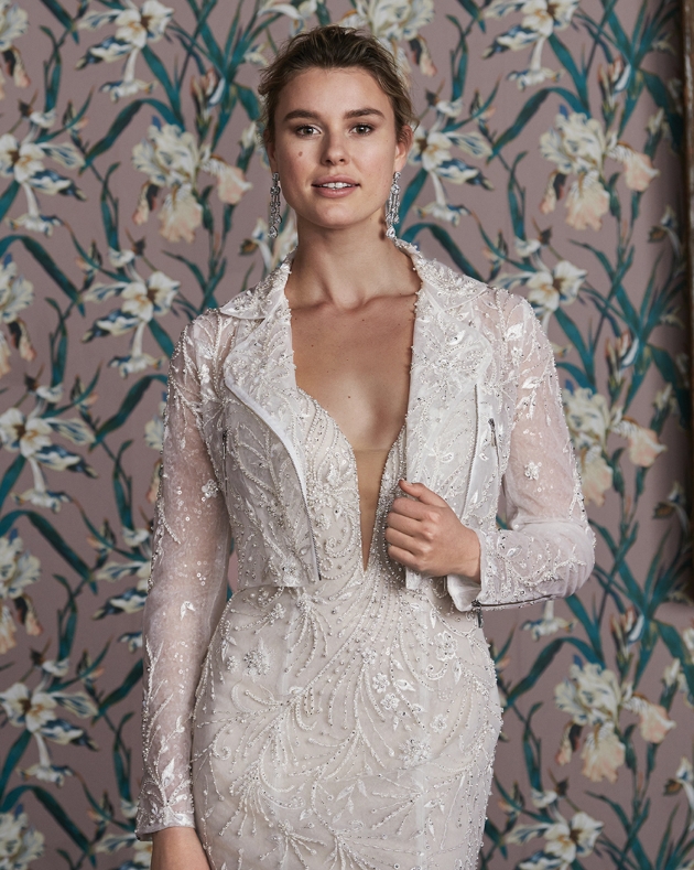 Model wears ivory wedding dress with heavily beaded jacket