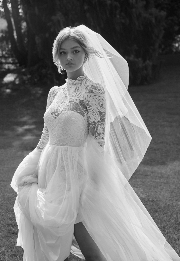 Model wearing a veil, wedding dress with see-through detail and split skirt 