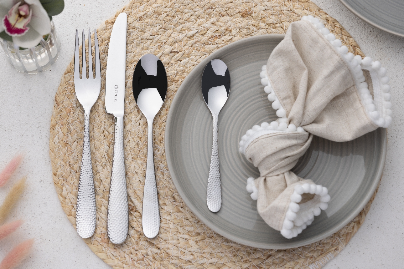 cutlery set on a grey plate and wicker place mat